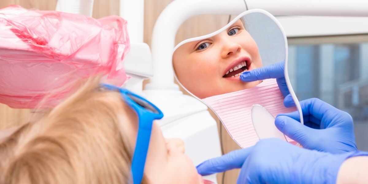 осмотр детским стоматологом молочных зубов