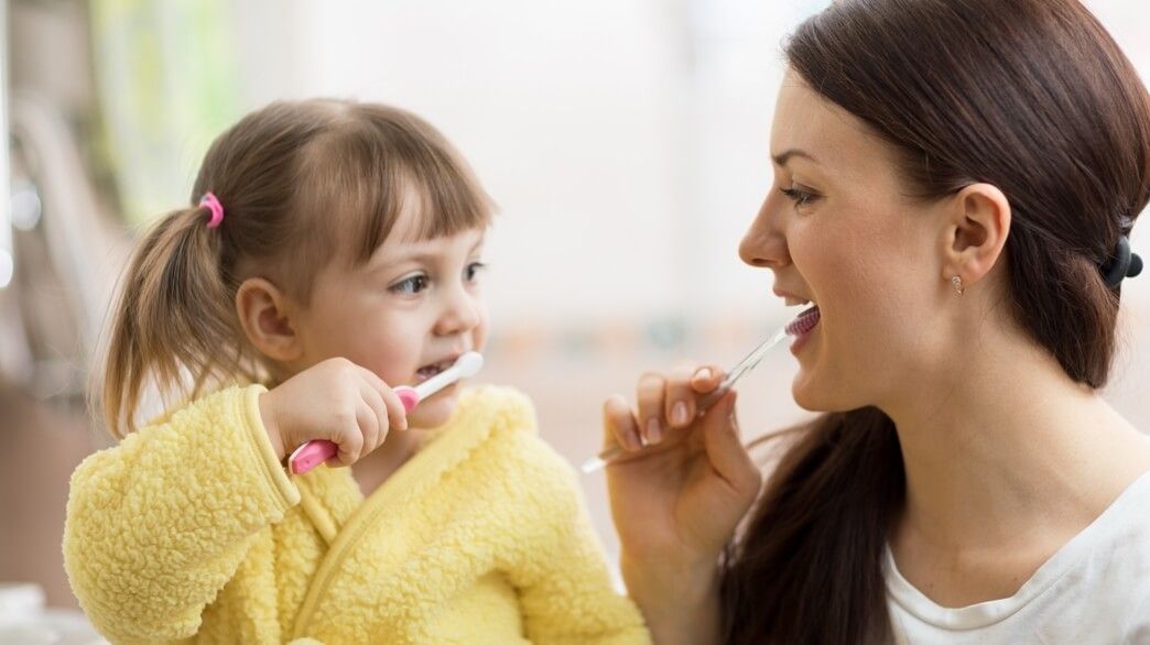 ребенок с мамой чистит зубы